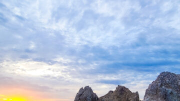 Sunset over the rocks and water in Cabo, Mexico - Holiday Travel Inspiration