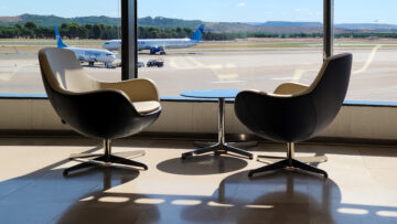 Two empty chairs in the VIP lounge upgrade with a view of the United runway