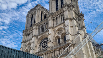 Front facade of Notre Dame de Paris Cathedral rising above the construction equipment