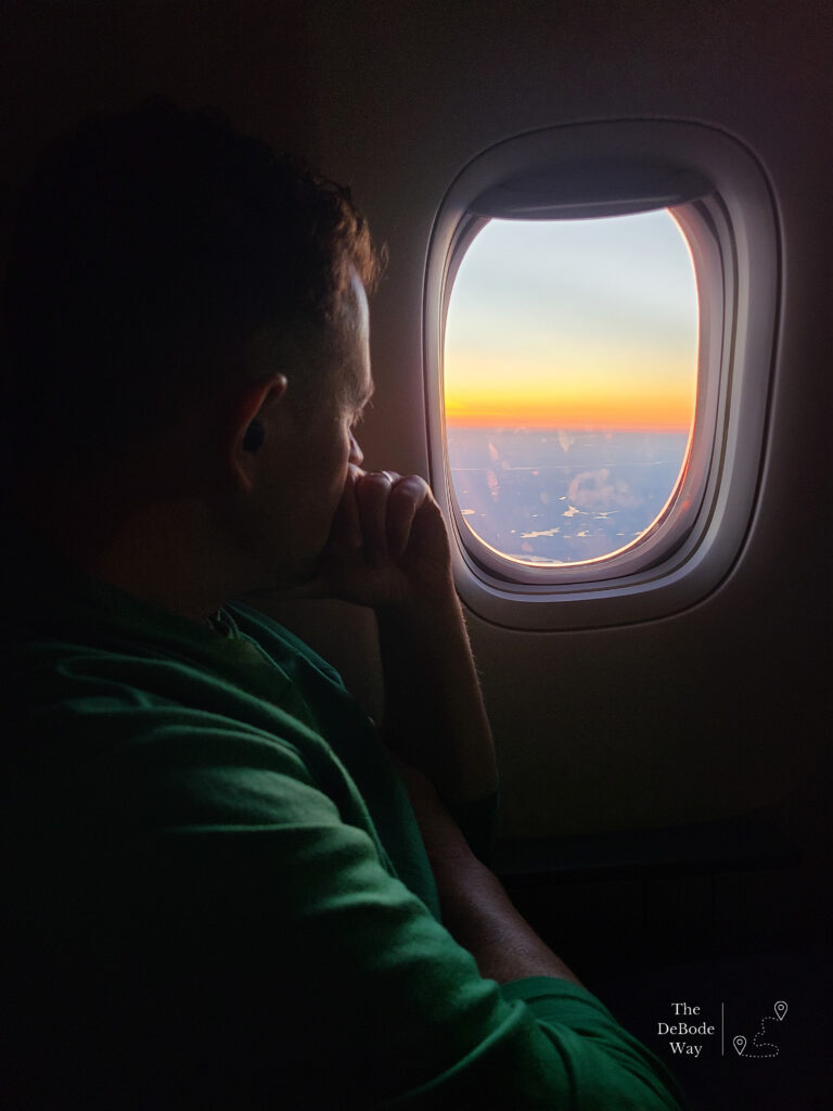 Jason staring out the plane window at the sunset - this can be anxiety-inducing for someone afraid of flying.