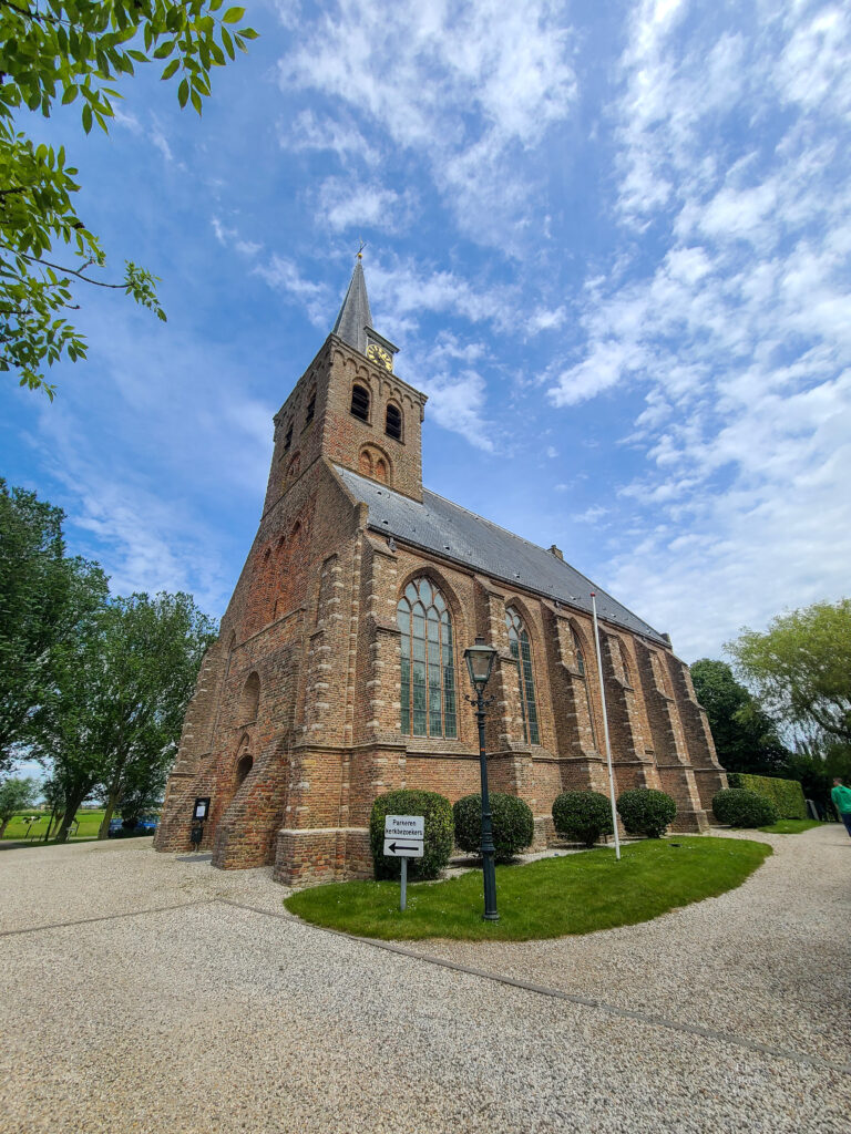 A small village church in t'Woudt, Holland against a blue sky