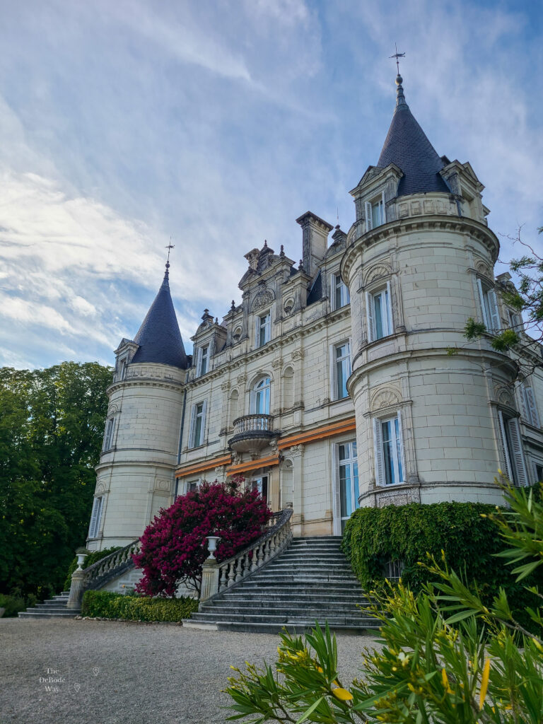 Front facade of Domaine de la Tortiniere Hotel outside of Tours, France against a cloudy sky.