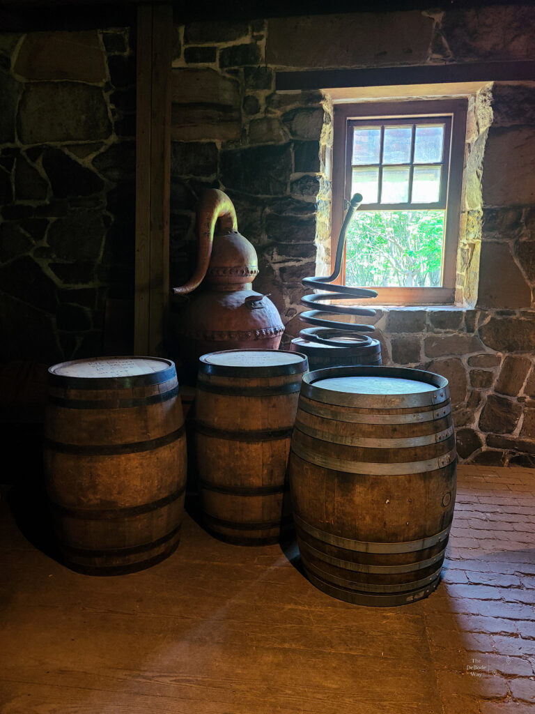 A collection of barrels, a still, and a worm near the window in the distillery at Mount Vernon