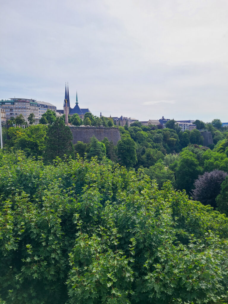A lush green view of Luxembourg with church spires in the distance