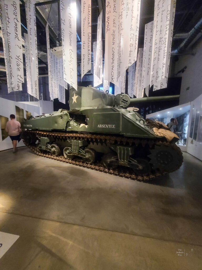 An American tank with a hole in the side inside the Bastogne War Museum