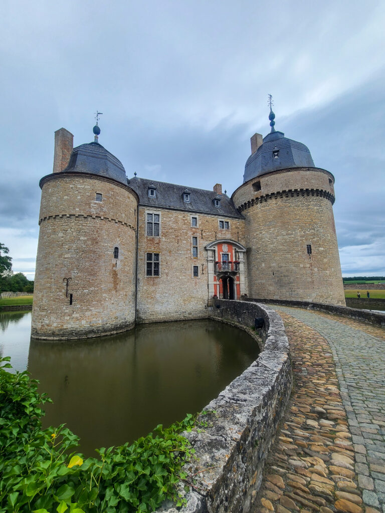 The bridge and moat leading to the front entrance of Chateau de Lavaux-Sainte-Anne between two round towers